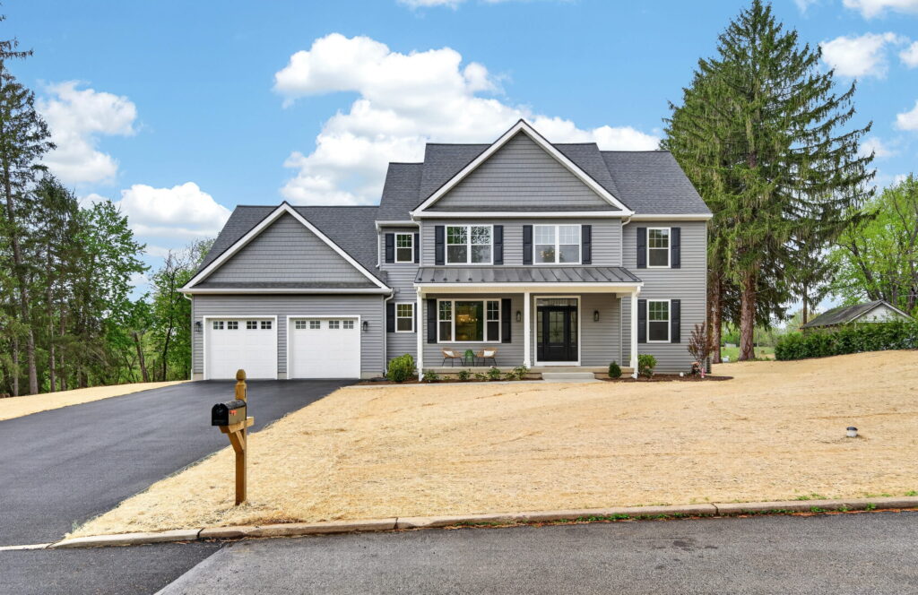 Front exterior of a large gray and white two-story home with a two-car garage