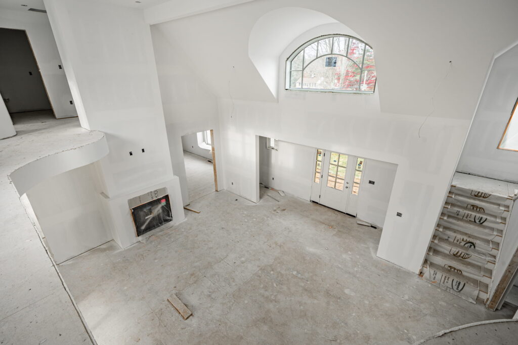 New-construction home interior under construction with a framed great room and arched window