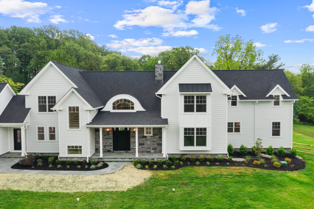 Front exterior of a white farmhouse-style two-story home with a dark roof