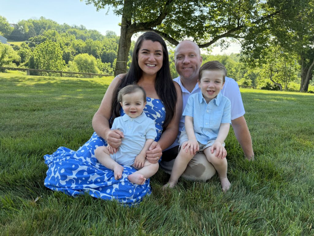 Young family sitting together on a sunny grassy lawn